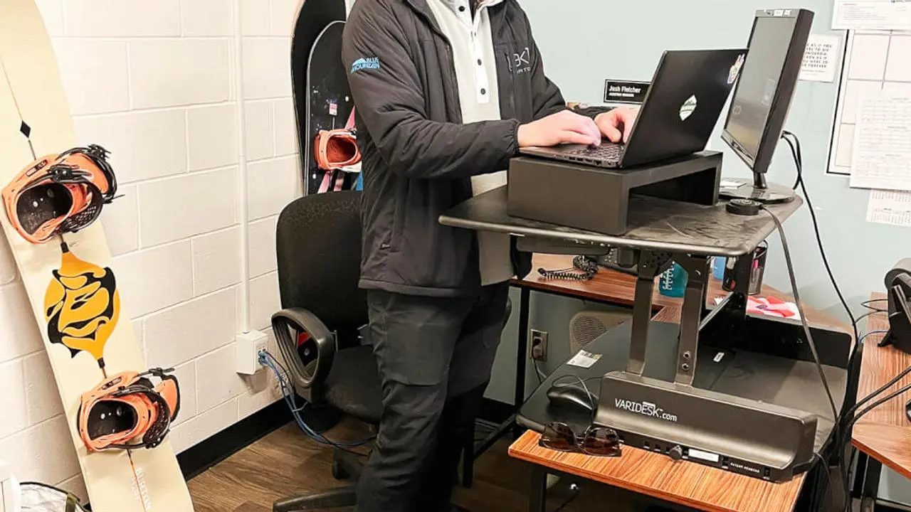 A person working on a computer at a standing desk