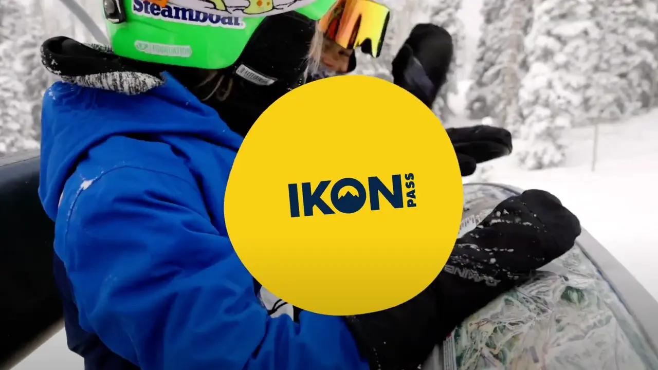 Skiers on a chairlift with the Ikon Pass logo in front of them.
