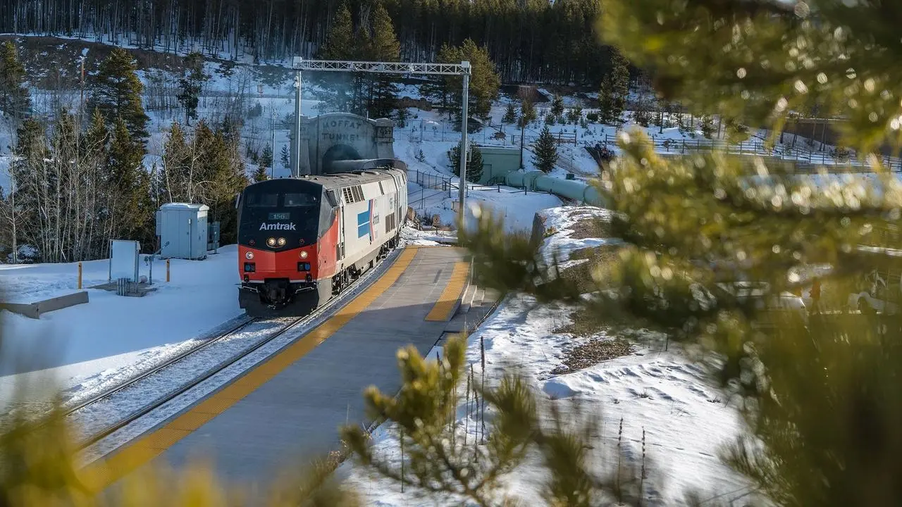 A train rolling on tracks through the mountains. 