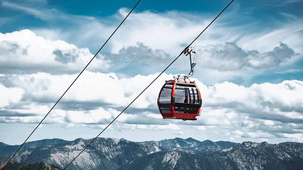 Scenic view of a gondola car ascending above a mountain setting
