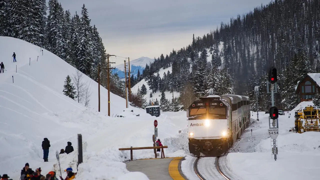 A train rolling on tracks through the mountains