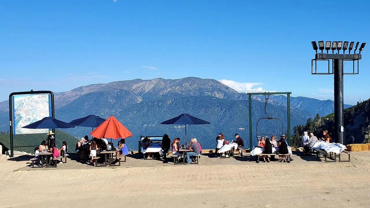 Scenic view of the mountains in the summer with people sitting at picnic tables