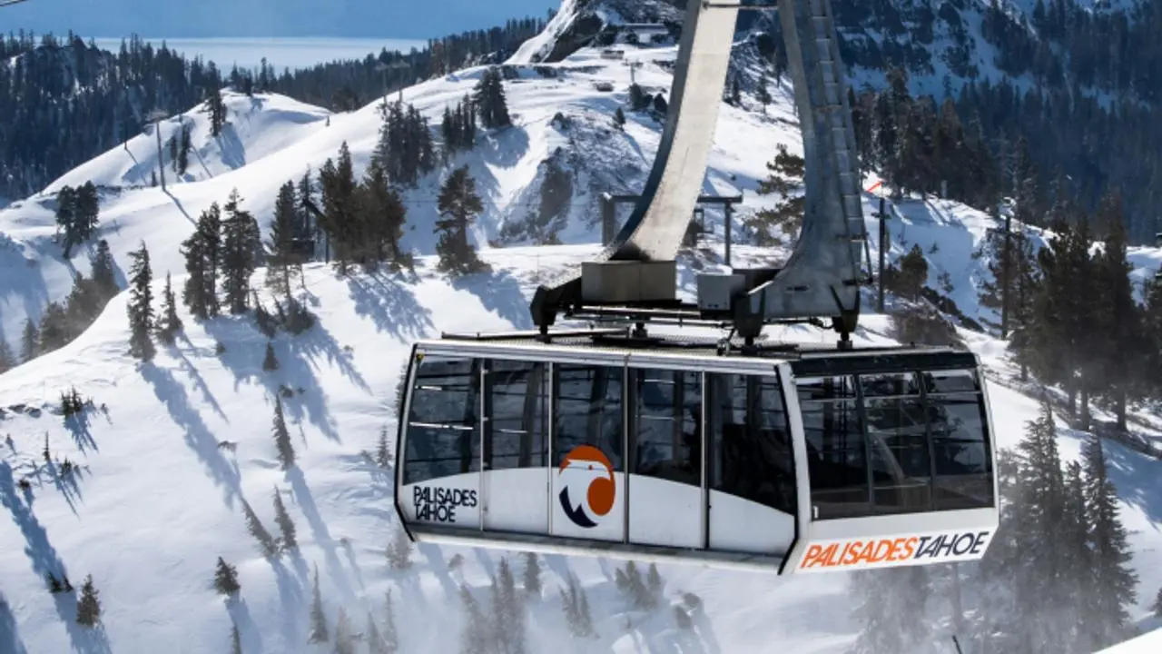 A tram car ascending up a snowy mountain