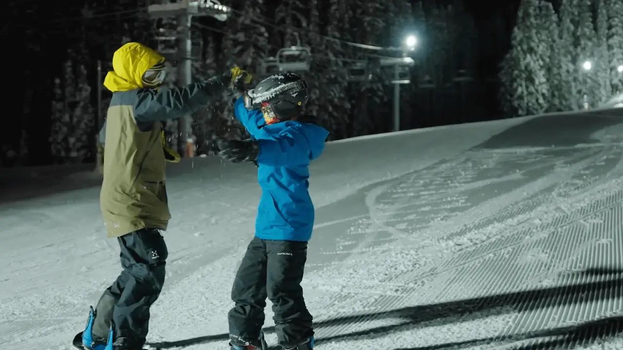 two people in snowboard gear giving each other a high five