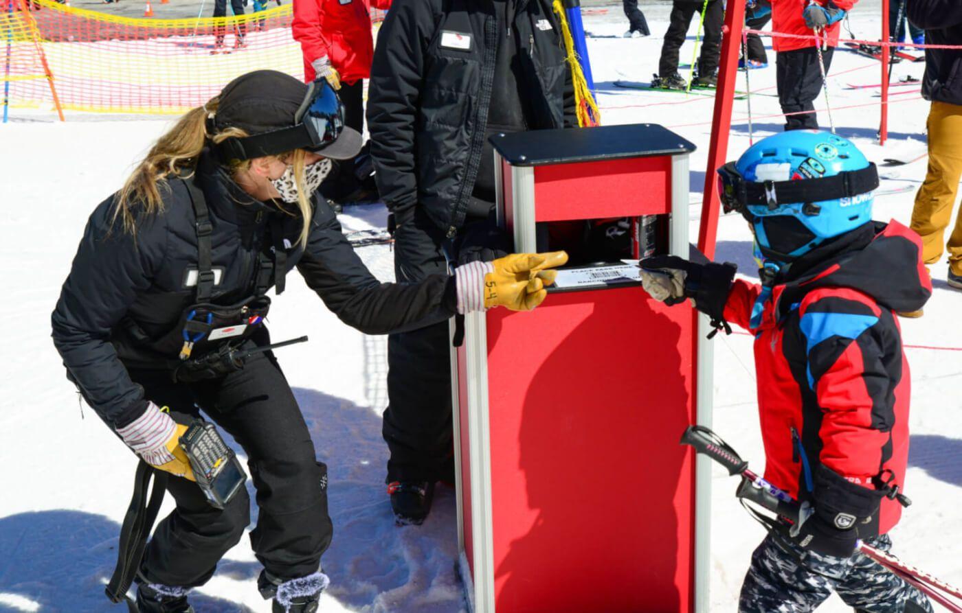 Adult wearing ski gear helping kid with a lift ticket