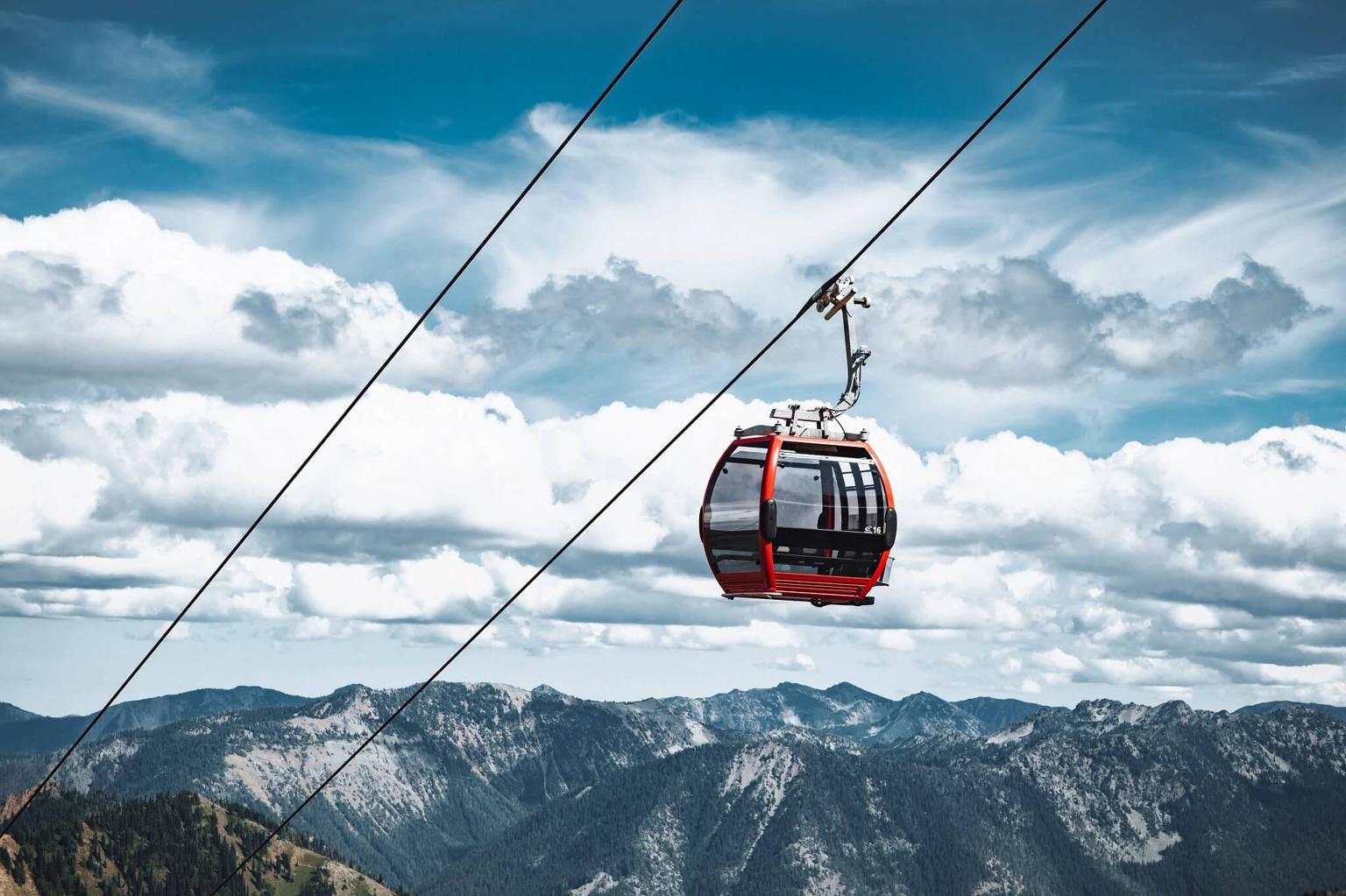 Scenic view of a gondola car ascending above a mountain setting