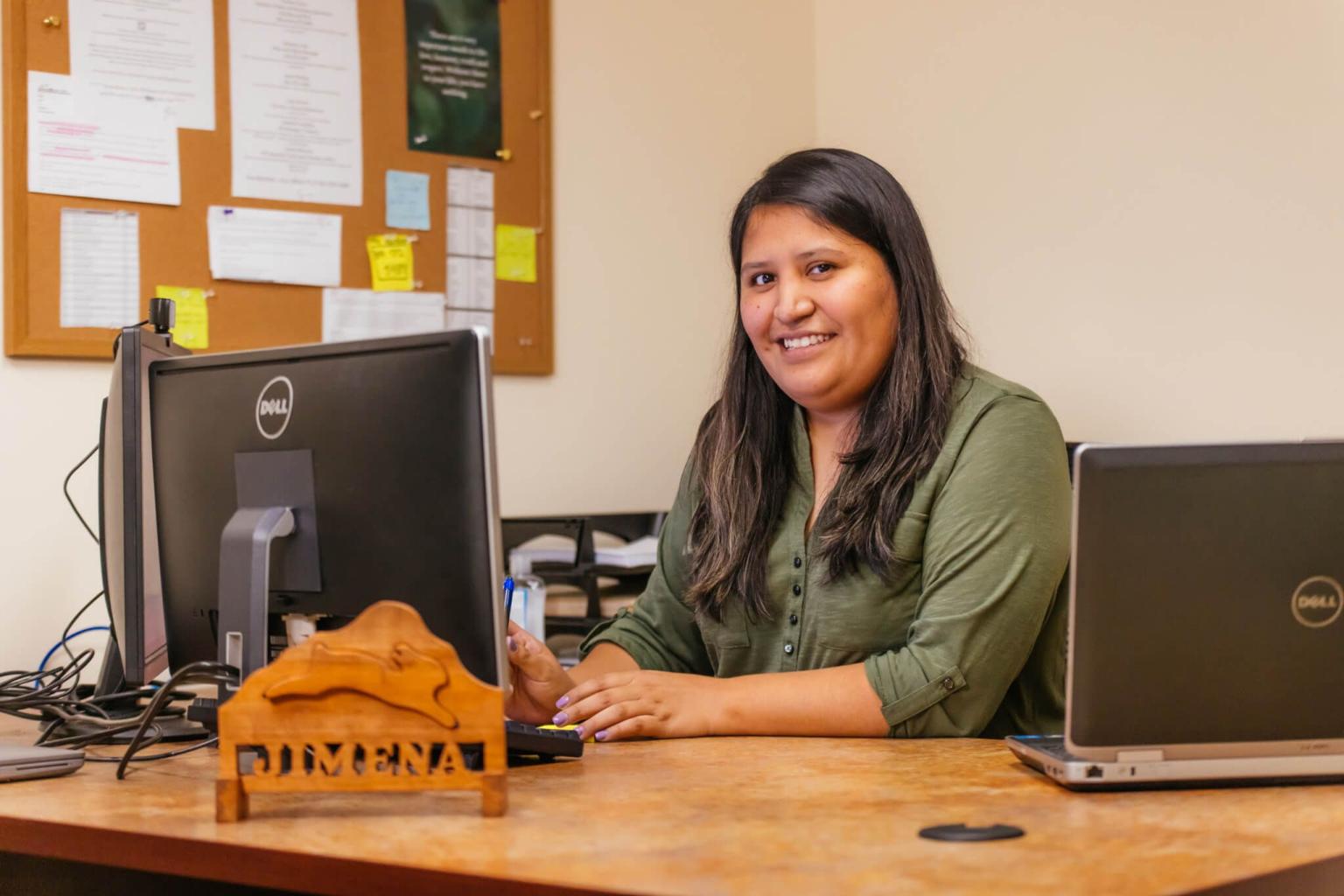 Person sitting at a desk smiling at the camera