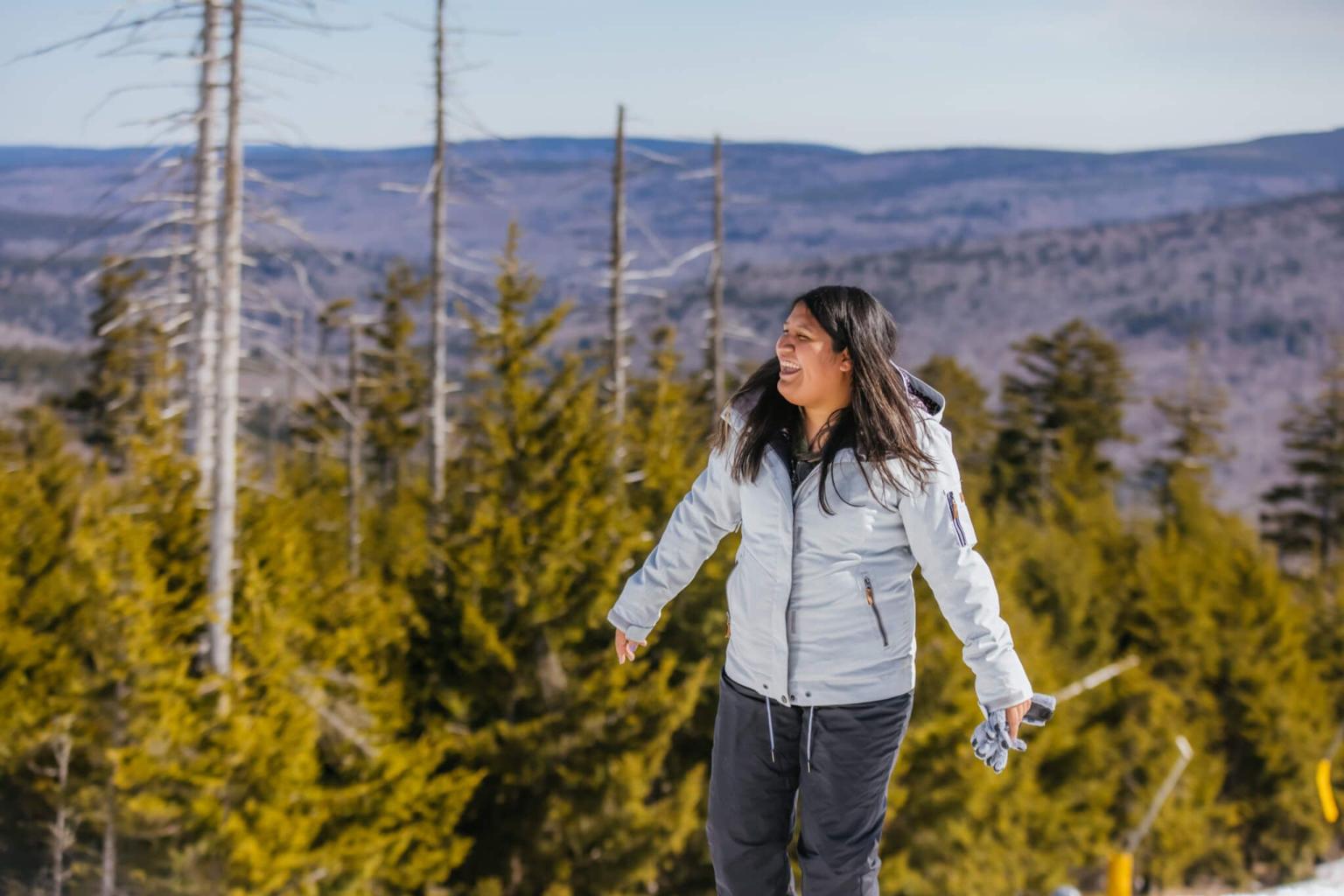 A person wearing winter gear at the top of a mountain