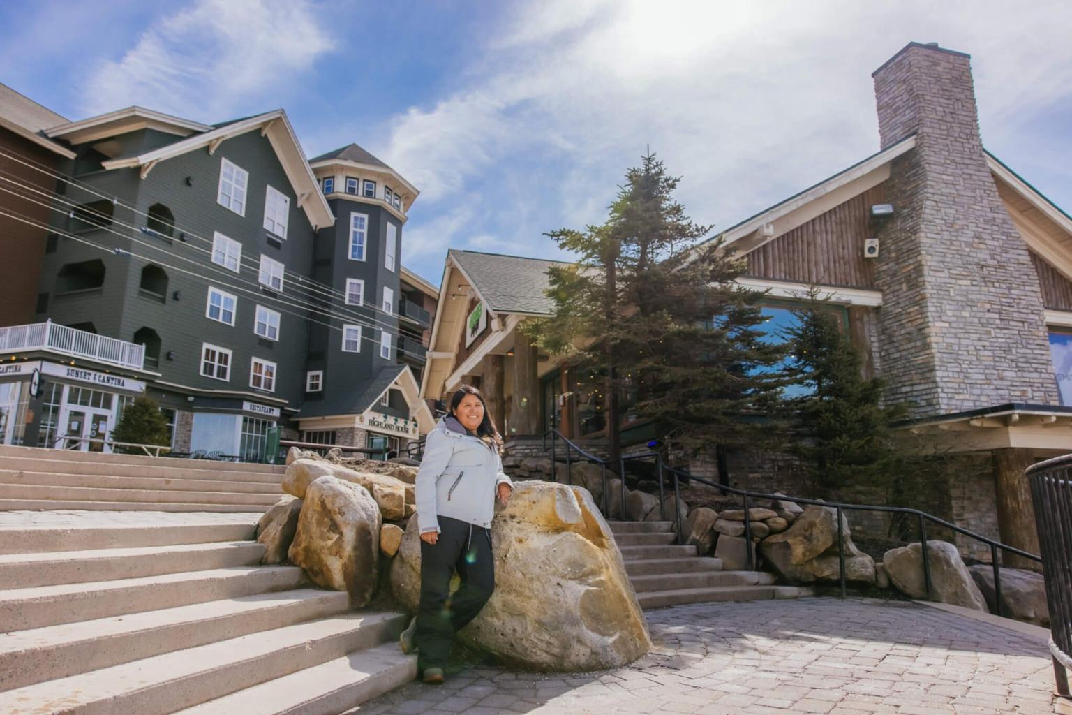 A person standing at the bottom of stairs outside in a mountain village